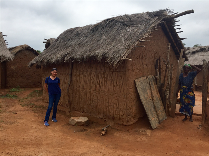 Christina next to a ghana home with a ghana resident pic